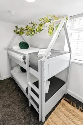 a white shelf with plants on it in a room at The Treehouse at The Hideaway STAMP SA in Blackpool
