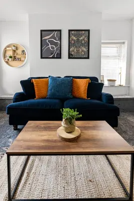 a living room with a blue couch and a coffee table at The Nest at The Hideaway STAMP SA in Blackpool
