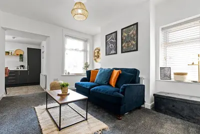 a living room with a blue couch and a table at The Nest at The Hideaway STAMP SA in Blackpool