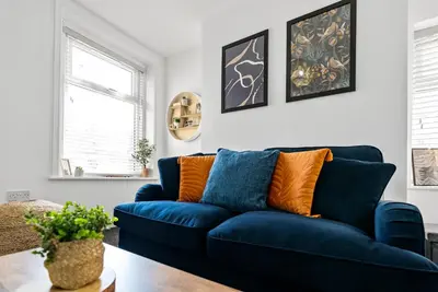 a blue couch in a living room with a table at The Nest at The Hideaway STAMP SA in Blackpool