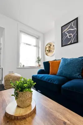a living room with a blue couch and a table at The Nest at The Hideaway STAMP SA in Blackpool