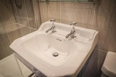 a white sink with two faucets in a bathroom at Hope and Anchor in Flookburgh