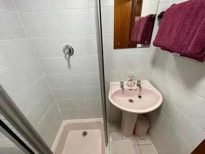 a white bathroom with a sink and a shower at Galaxy Hotel in Blackpool