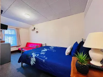 a bedroom with a blue bed and a red chair at Galaxy Hotel in Blackpool