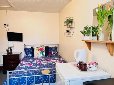 a small bedroom with a bed with a blue bedspread at Galaxy Hotel in Blackpool