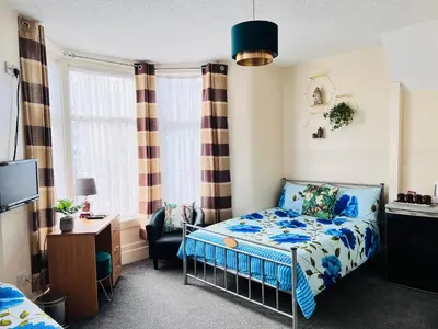 a small bedroom with a bed and a chair at Galaxy Hotel in Blackpool