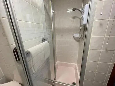 a shower with a glass door in a bathroom at Galaxy Hotel in Blackpool