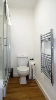 a bathroom with a toilet and a glass shower at The Kop End Penthouse in Liverpool