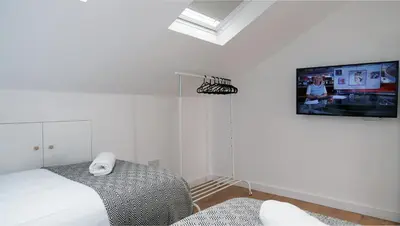 a bedroom with a bed and a tv on the wall at The Kop End Penthouse in Liverpool