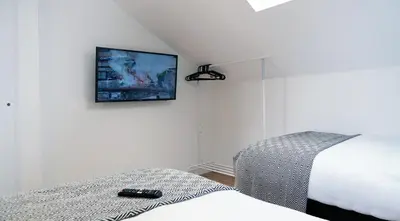 a bedroom with a bed and a tv on the wall at The Kop End Penthouse in Liverpool