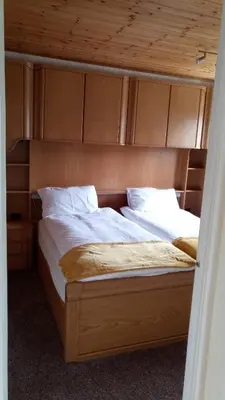 a bed in a bedroom with a wooden headboard at Beeston House in Thornton
