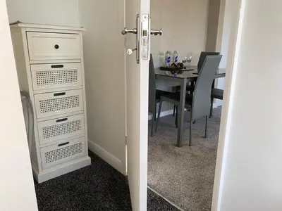 a room with a table and a white dresser with a dining room at Beach Front Apartment with Free Parking, St Annes in Lytham St Annes