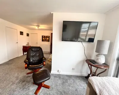 a room with a chair and a television on a wall at Beach Front Apartment with Free Parking, St Annes in Lytham St Annes
