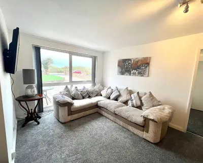 a living room with a couch and a large window at Beach Front Apartment with Free Parking, St Annes in Lytham St Annes