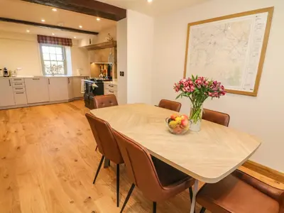 a dining room table with a vase of flowers on it at Lanshaw House in Lancaster