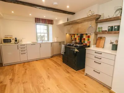 a large kitchen with white cabinets and a wooden floor at Lanshaw House in Lancaster
