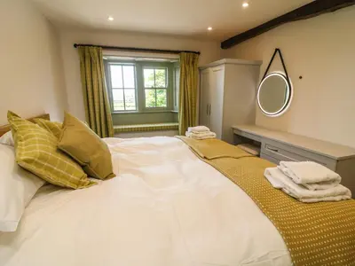 a bedroom with a large bed with a mirror on the wall at Lanshaw House in Lancaster