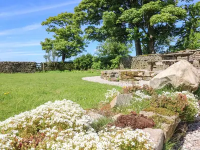 a garden with white flowers and a stone wall at Lanshaw House in Lancaster