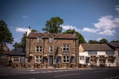 an old brick building on the side of a street at The Waddington Arms in Waddington