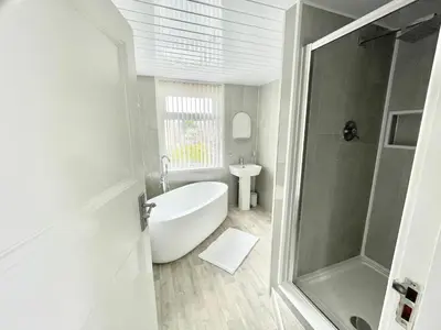 a bathroom with a bath tub and a sink at Croyden villa in Blackpool
