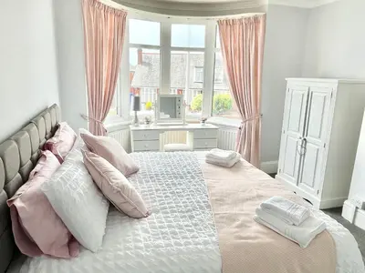 a bedroom with a bed with pink and white pillows at Croyden villa in Blackpool