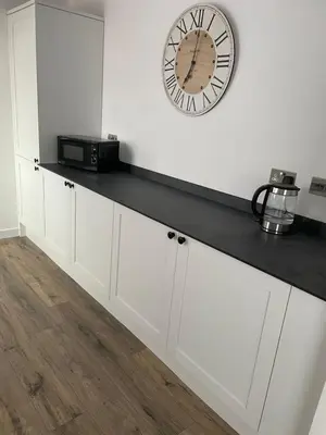 a kitchen counter with a clock on the wall at Croyden villa in Blackpool