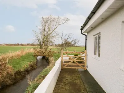 a gate to a house next to a river at The Annex in Ulverston