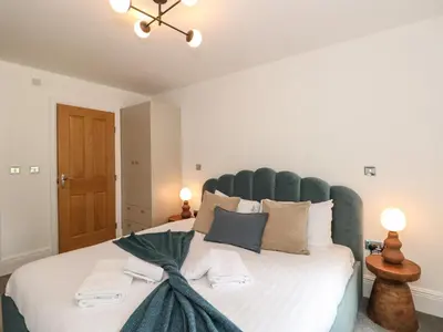 a bedroom with a large bed with a green headboard at The Kennedy House Stone Cross Mansion in Ulverston