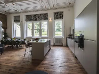 a large room with a kitchen with a dining table at The Wilfred Suite Stone Cross Mansion in Ulverston