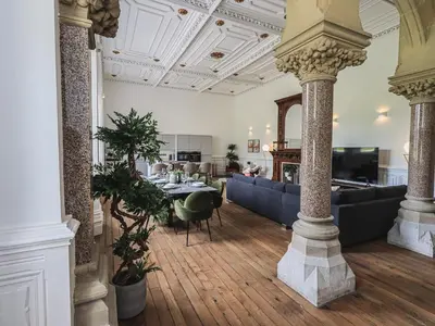 a living room with a table and chairs in a building at The Wilfred Suite Stone Cross Mansion in Ulverston