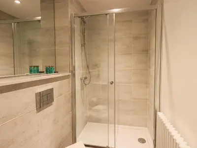 a shower with a glass door in a bathroom at The Wilfred Suite Stone Cross Mansion in Ulverston