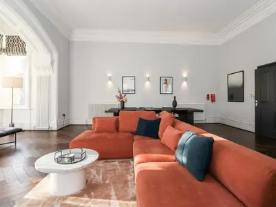 a living room with a orange couch and a table at The Mary Maude Suite Stone Cross Mansion in Ulverston