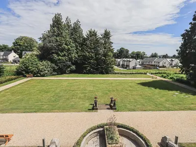 two people sitting on a bench in a large park at The Mary Maude Suite Stone Cross Mansion in Ulverston