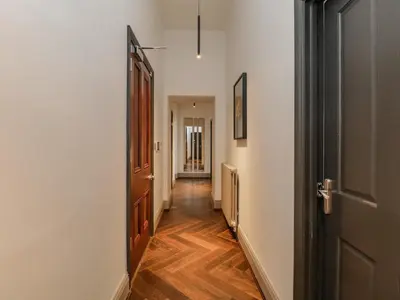 a hallway with white walls and a wooden door at The Mary Maude Suite Stone Cross Mansion in Ulverston