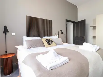 a bedroom with a large white bed with towels on it at The Mary Maude Suite Stone Cross Mansion in Ulverston