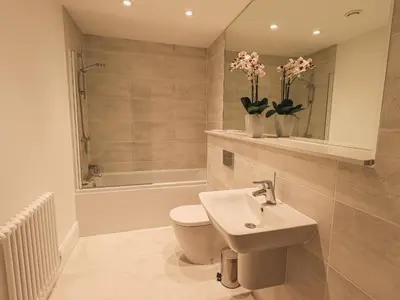 a bathroom with a toilet and a sink and a shower at The Mary Maude Suite Stone Cross Mansion in Ulverston