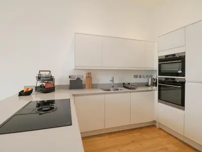 a kitchen with white cabinets and a counter top at William Tower Suite Stone Cross Mansion in Ulverston
