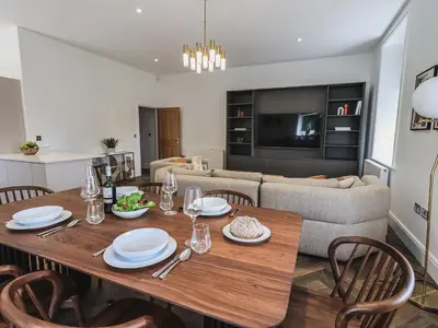 a dining room and living room with a table and chairs at The Lucy Suite Stone Cross Mansion in Ulverston