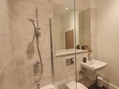 a bathroom with a shower and a toilet and a sink at The Lucy Suite Stone Cross Mansion in Ulverston