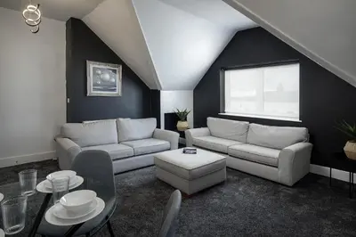 a living room with two couches and a table at St Chads Suites by Central Beach Leisure in Blackpool
