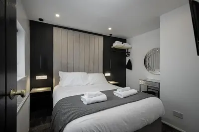 a bedroom with a bed with two towels on it at St Chads Suites by Central Beach Leisure in Blackpool