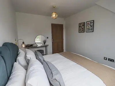 a bedroom with a large bed with white sheets at The Mabel Suite Stone Cross Mansion in Ulverston
