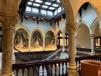 an ornate staircase in a building with paintings on the wall at The Mabel Suite Stone Cross Mansion in Ulverston
