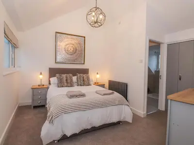a bedroom with a bed and a chandelier at The Lookout in Millom
