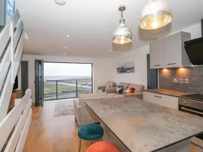 a kitchen and living room with a view of the ocean at The Lookout in Millom