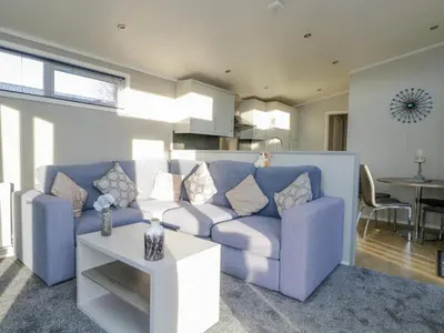 a living room with a blue couch and a table at Yealand 36 in Carnforth