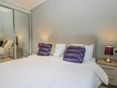 a bedroom with a large white bed with purple pillows at Yealand 36 in Carnforth