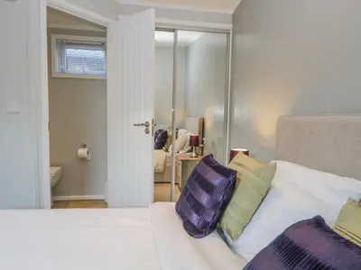 a bedroom with a bed with purple and green pillows at Yealand 36 in Carnforth