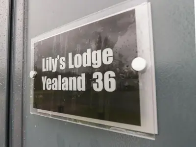 a sign on a door with the words lilys lodge zealand at Yealand 36 in Carnforth