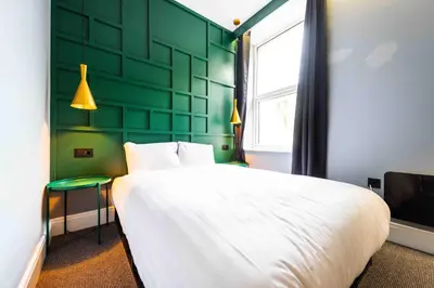 a bedroom with a white bed and a green wall at The Luxury Penthouse by Sasco Apartments in Blackpool